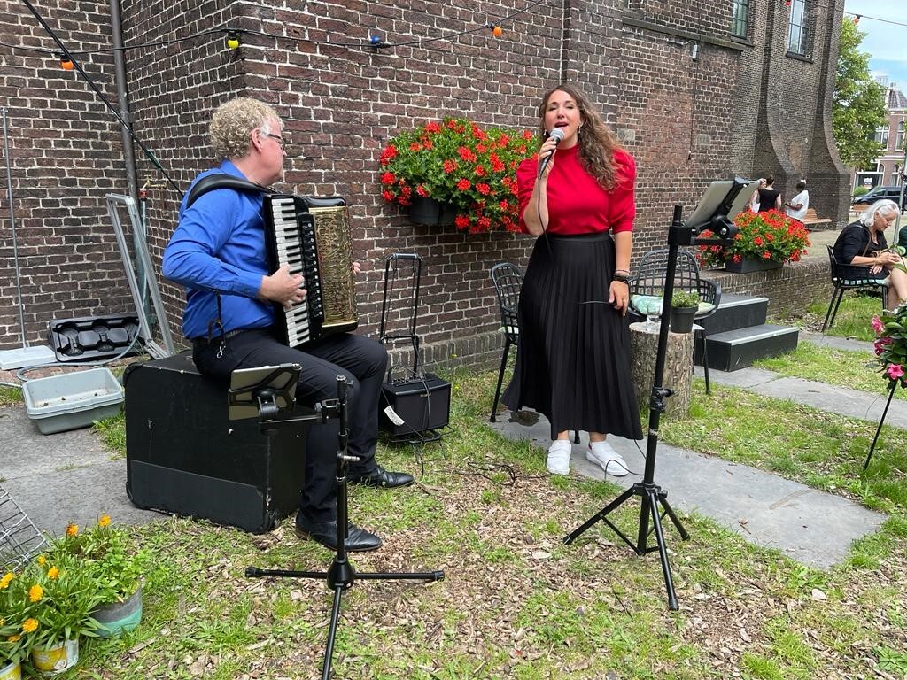 Foto met muzikant en zangeres bij de Bullekerk in Zaandam